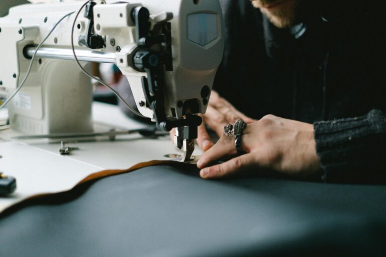 Close-up of hands using an industrial sewing machine to create garments.